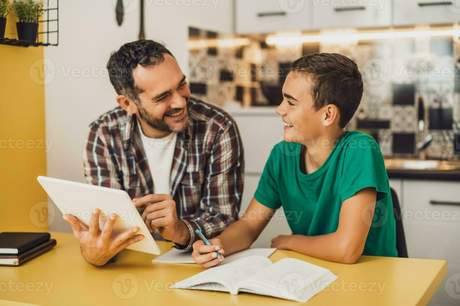Father is helping his son with learning. They are doing homework together. photo