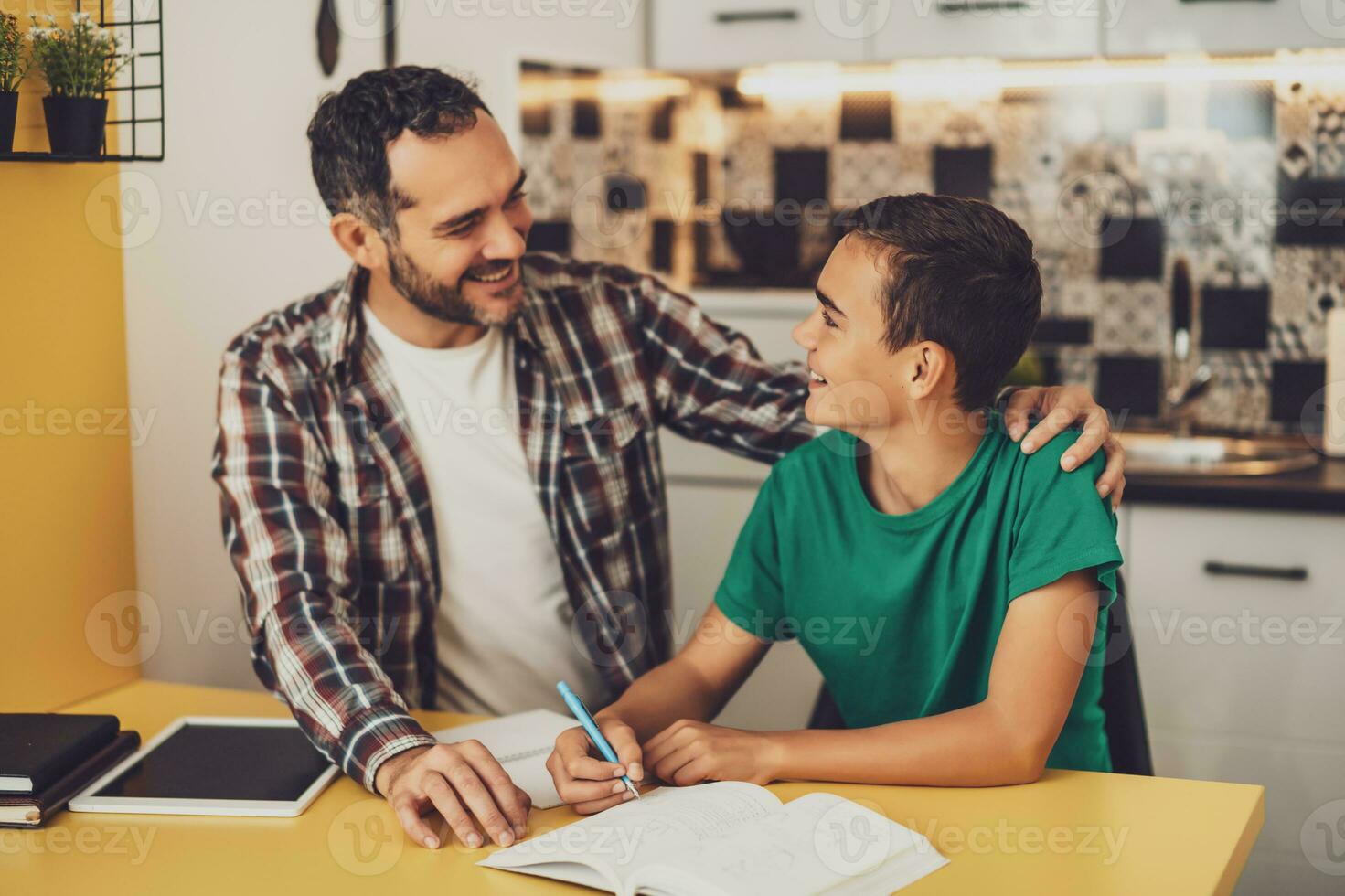 Father is helping his son with learning. They are doing homework together. photo