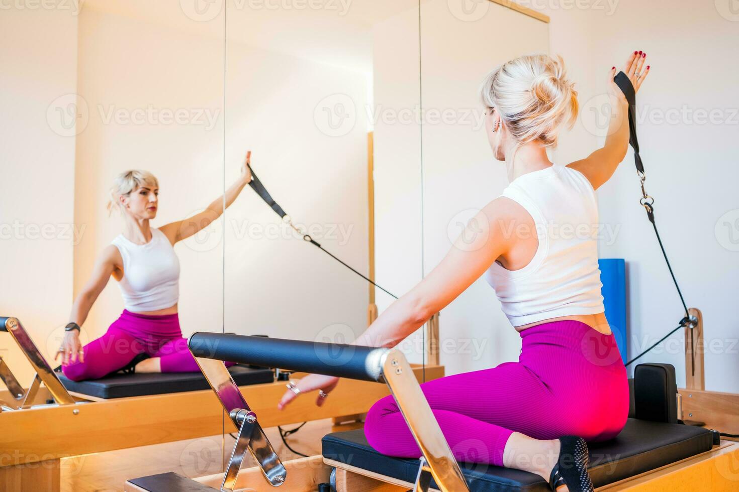 rubia mujer es hacer ejercicio en pilates reformador cama en su hogar. foto