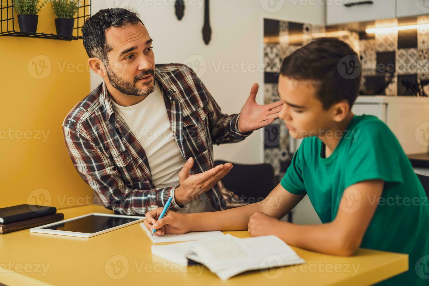 Father is helping his son with learning. They are doing homework together. photo