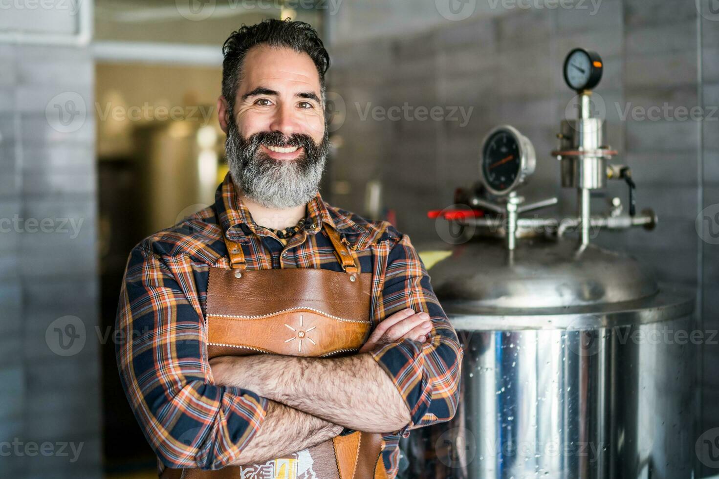 Man is working at craft beer factory. He is operating machinery in brewery. Small family business, production of craft beer. photo