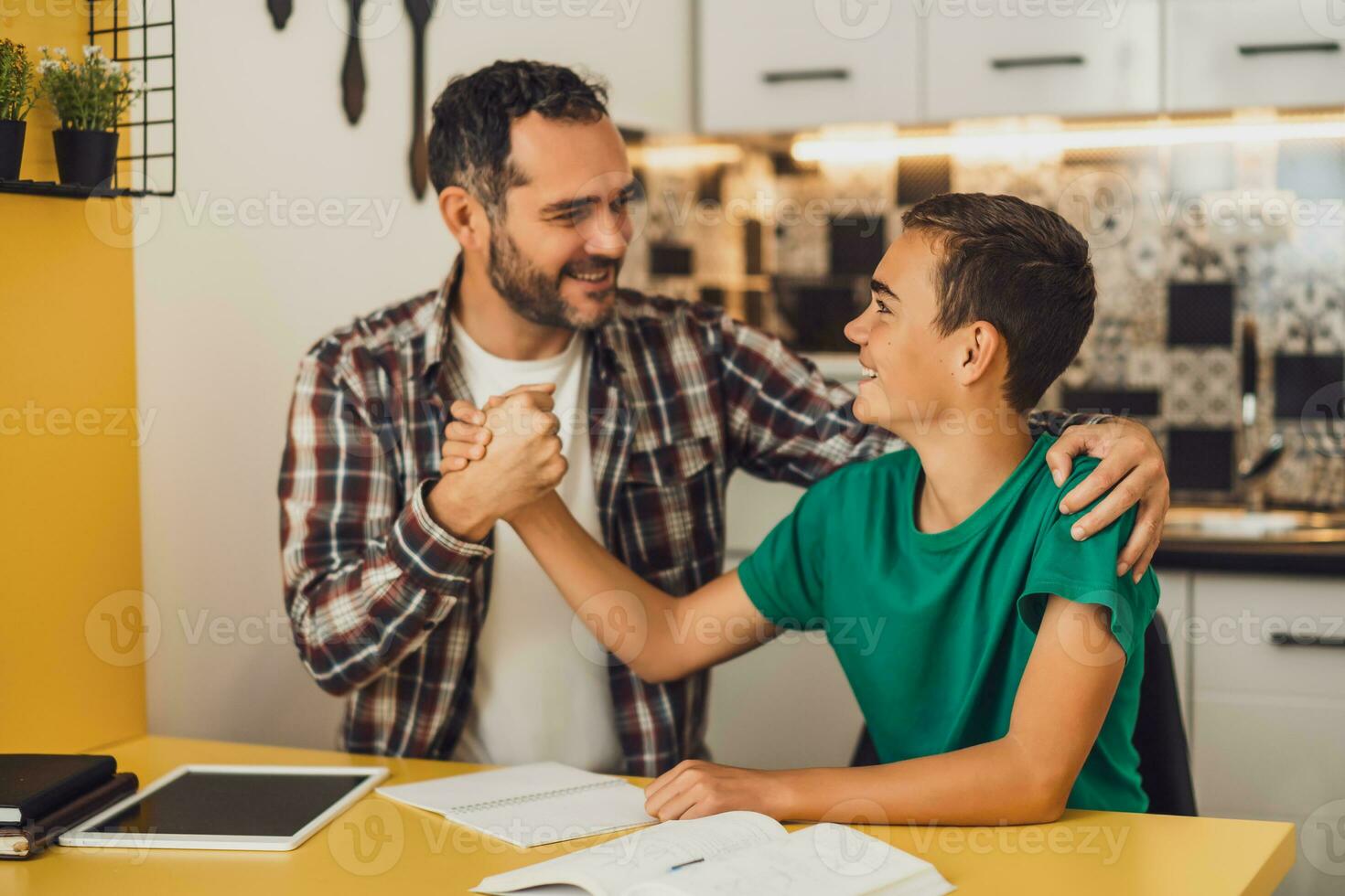 Father is helping his son with learning. They are doing homework together. photo