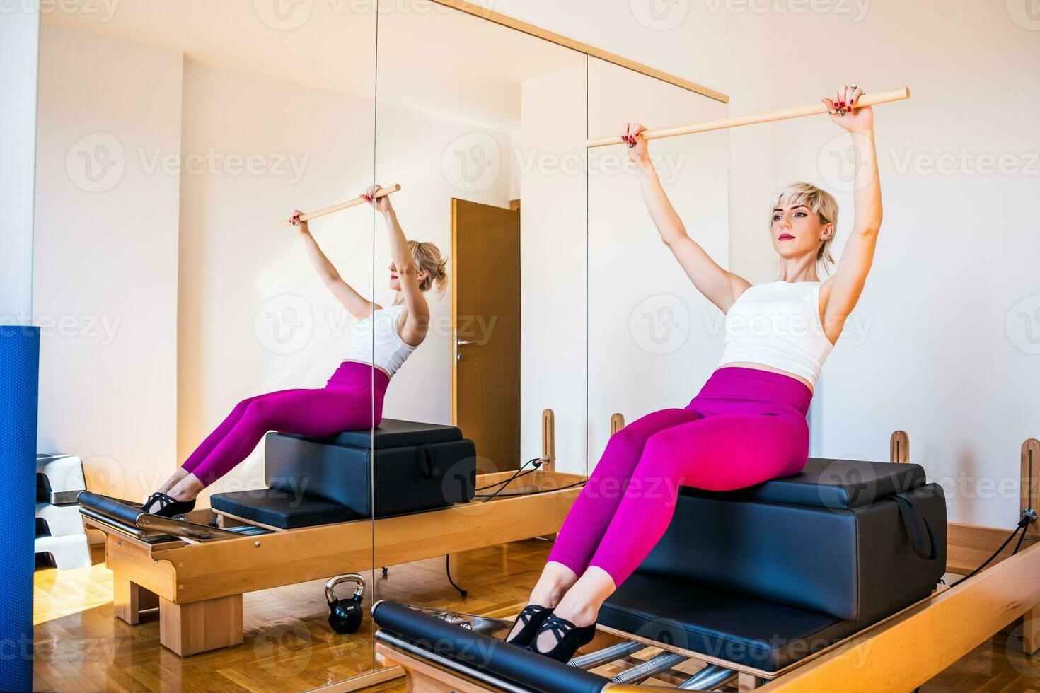 rubia mujer es hacer ejercicio en pilates reformador cama en su hogar. foto