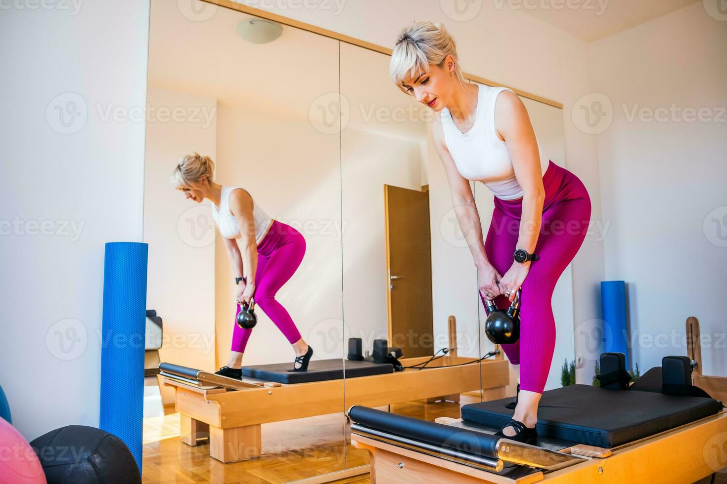 rubia mujer es hacer ejercicio en pilates reformador cama en su hogar. foto