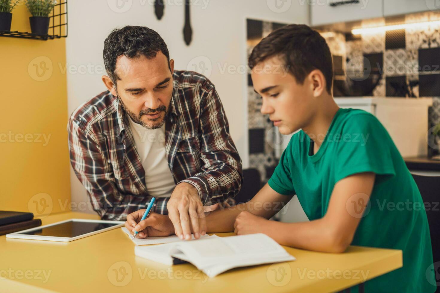 Father is helping his son with learning. They are doing homework together. photo