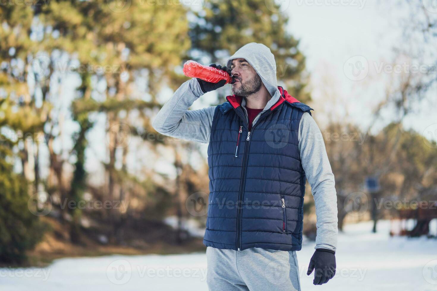 Adult man is exercising on the park in wintertime. photo