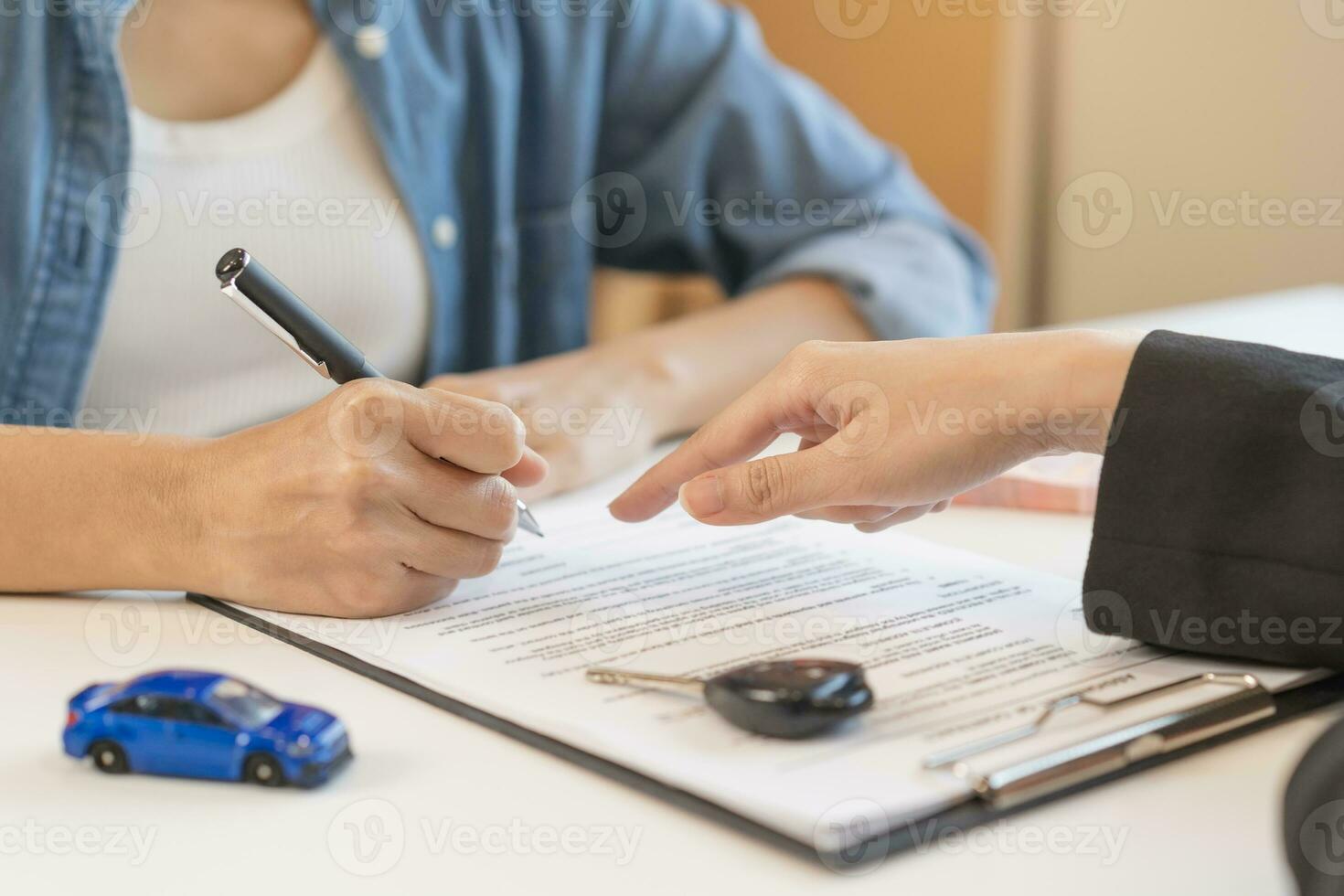 Business car rental company service, hand of agent dealer is pointing to purchase contract of tenant to sign signature on document, new owner after signed rental , vehicle sales agreement. photo