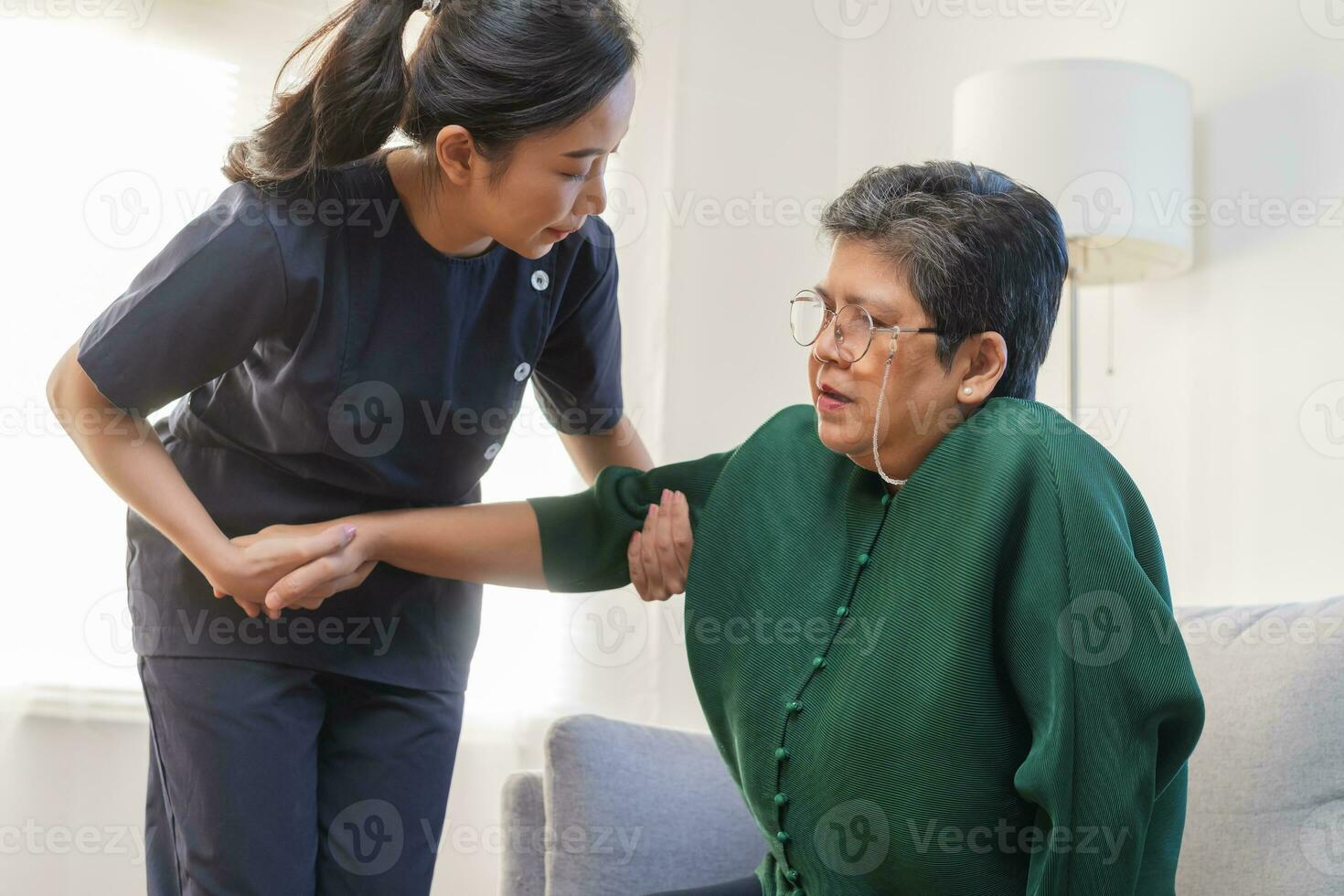 Asian young woman caregiver, carer supporting elderly, aged patient at home, cure or treatment disease of grandmother after retirement, support and service help together. Health care, check up medical photo