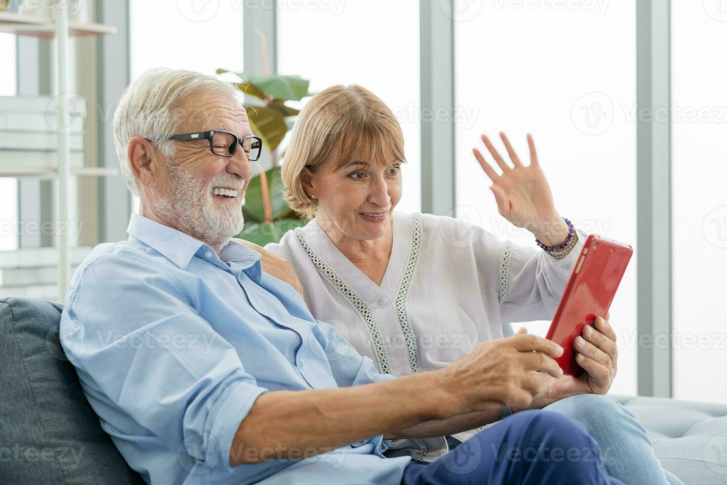 Happy husband and wife senior couple elderly family, caucasians mature, adult lover and retired man, woman using tablet communicating, shopping online, reading news on sofa at home together. photo