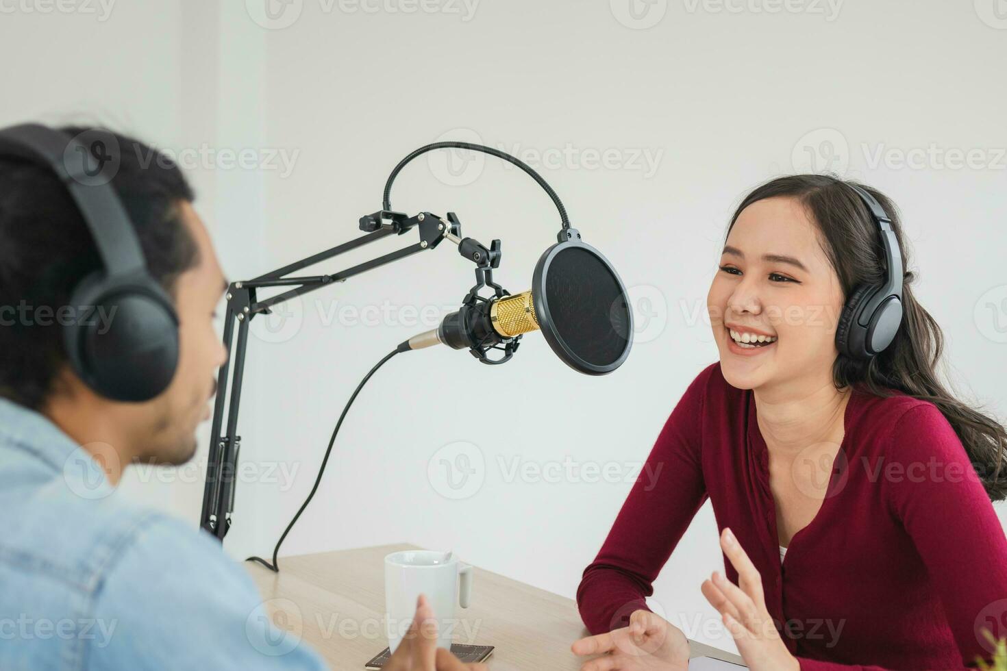 Smile two asian young woman, man radio hosts in headphones, microphone while talk, conversation, recording podcast in broadcasting at studio together. Technology of making record audio concept. photo
