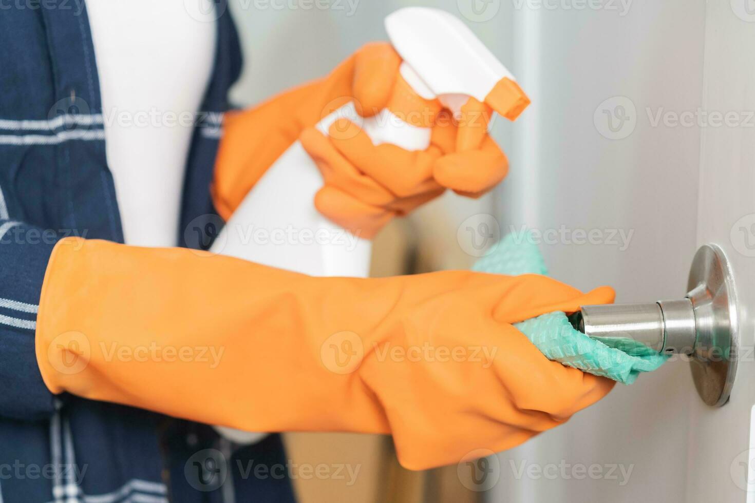 mano de asiático joven mujer, niña limpieza frota polvo, utilizar harapos, rociar botella en mando puerta de baño habitación a hogar. casa higiene limpiar, limpiador gente, equipo o herramienta para limpieza. foto