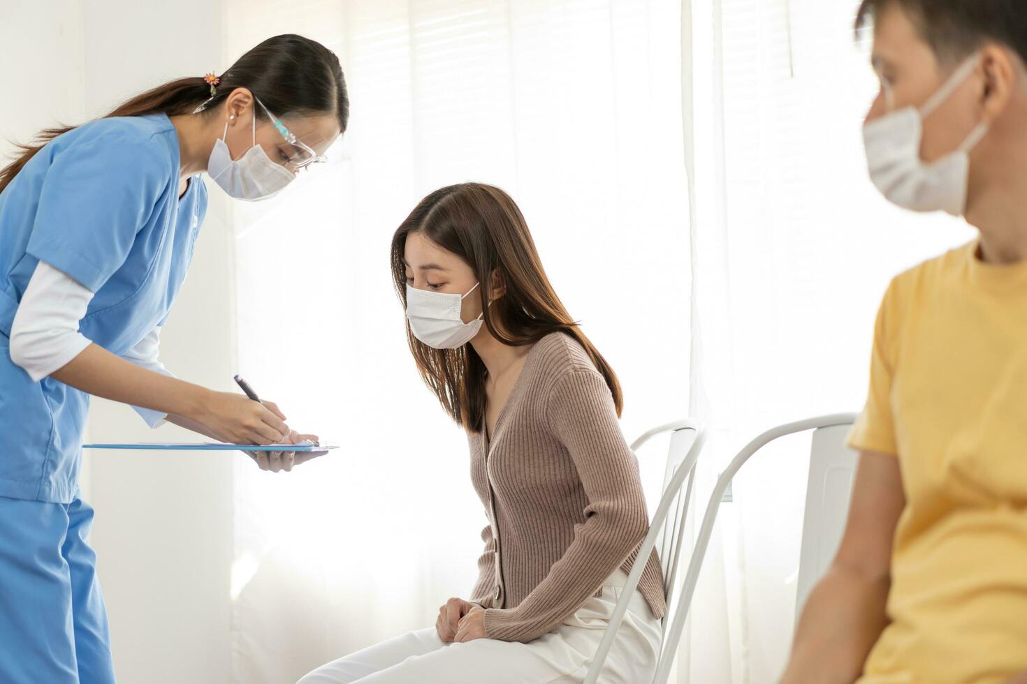 COVID-19, corona asiático joven mujer paciente consiguiendo a vacuna mientras esperando cola enfermero preguntar personal información. vacunación, inmunización o enfermedad prevención en contra gripe o virus pandemia. foto