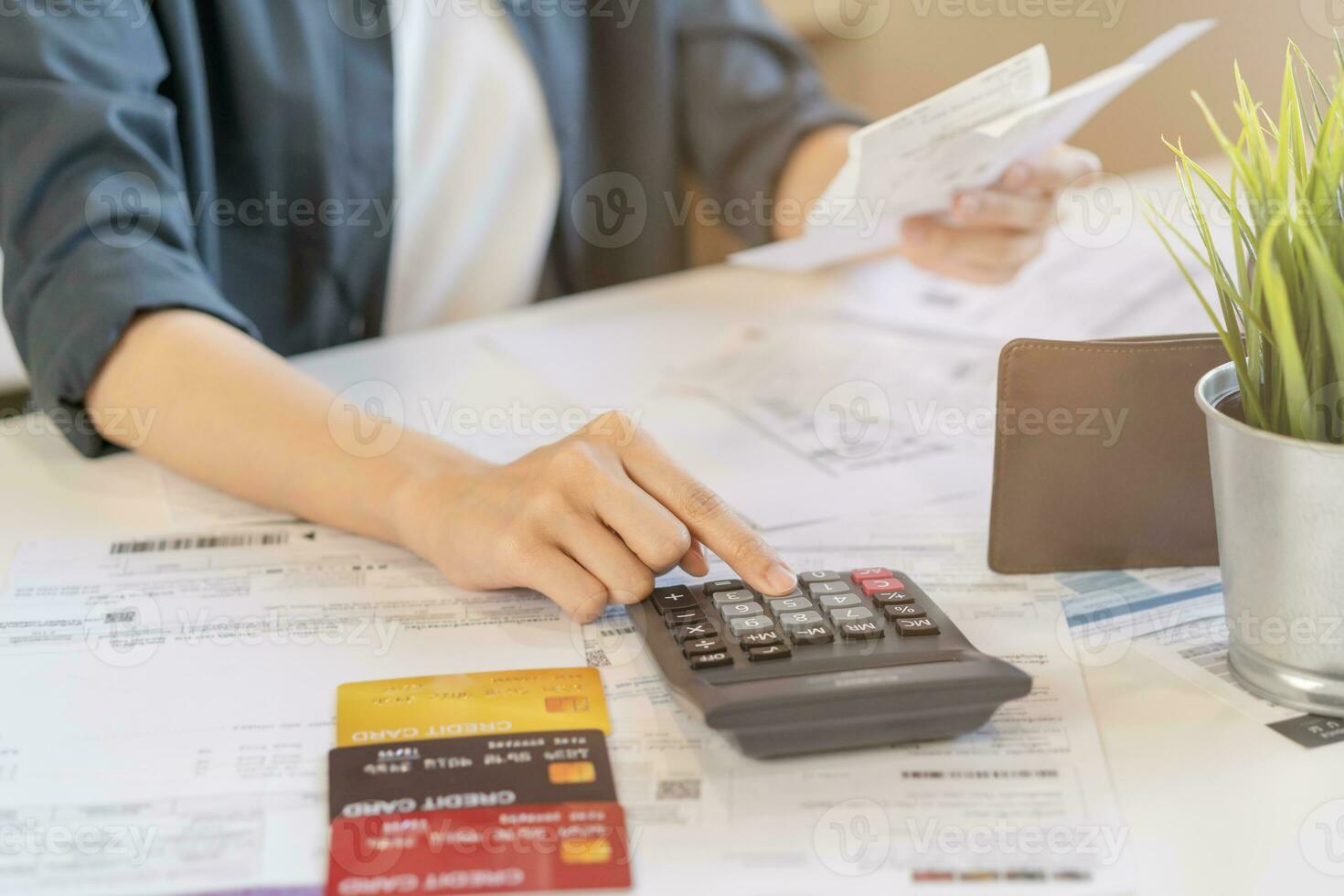 Close up hand of stress asian young employee business woman calculate tax income and expenses, bills, credit card for payment or payday on table at home office. Financial, finance people concept. photo