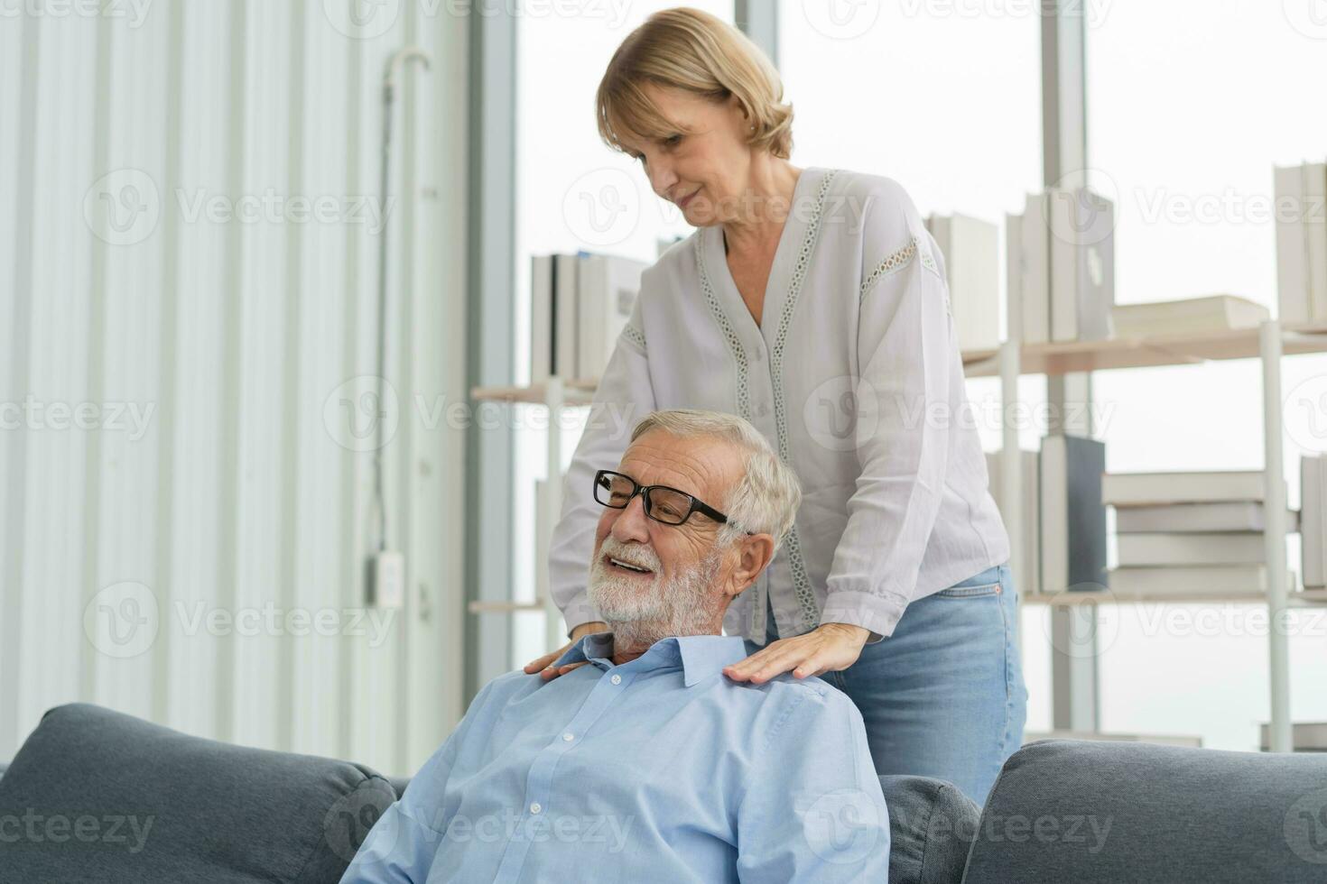 Health, body muscles stiff problem of senior couple, caucasians mature, adult retired husband, wife pain with back pain ache holding massaging rubbing shoulder hurt or sore, painful sitting on sofa. photo