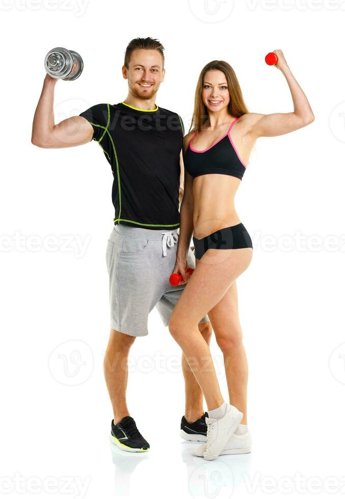 Sport couple - man and woman with dumbbells on the white photo