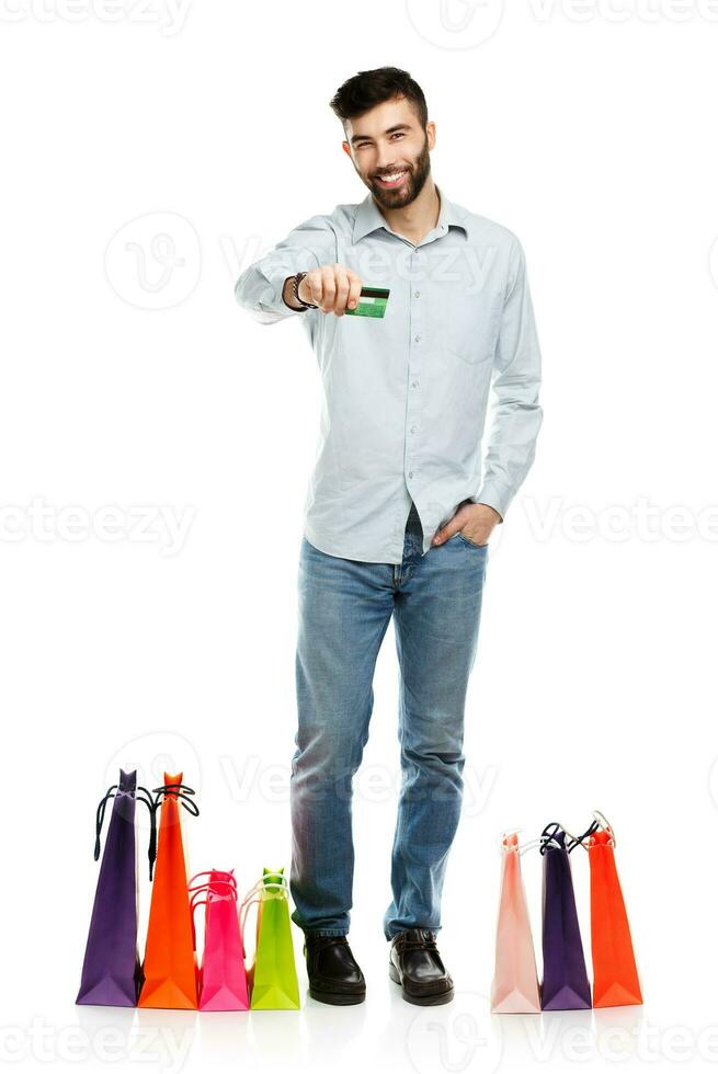 Handsome man with shopping bags and holding credit card photo