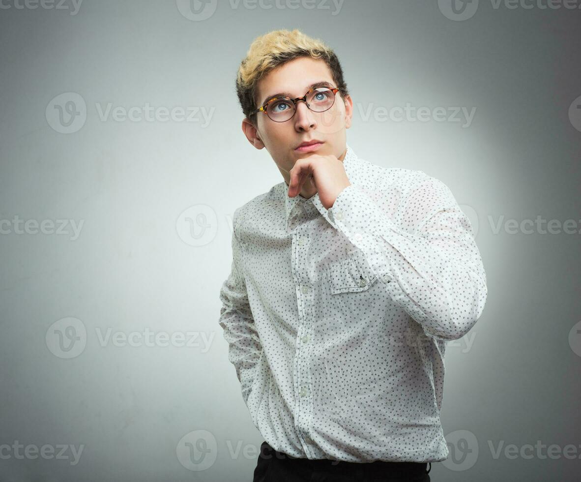 Young man with glasses thinking photo