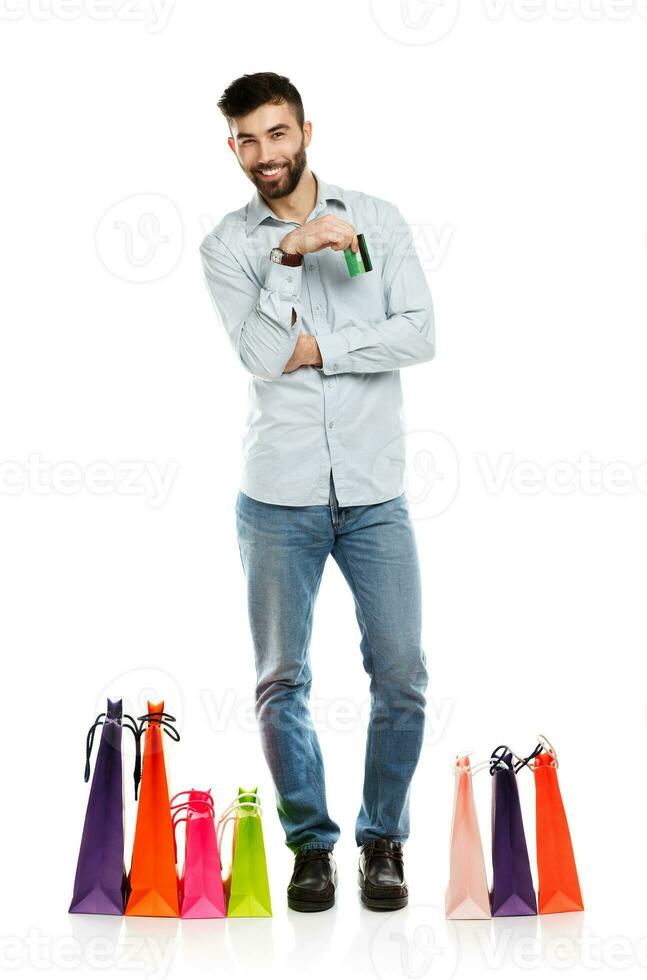 Handsome smiling man with shopping bags and holding credit card photo