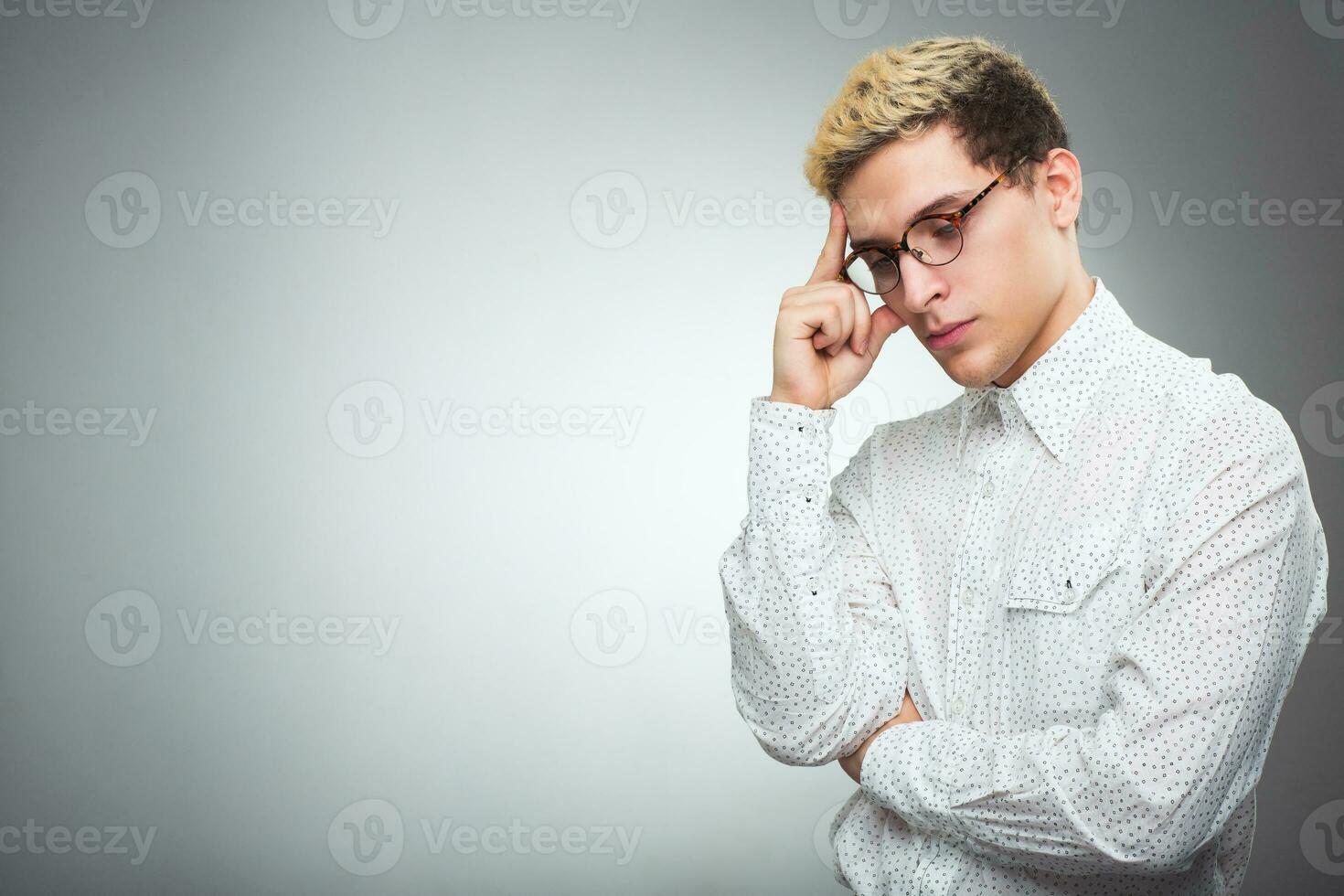 Young man with glasses thinking photo