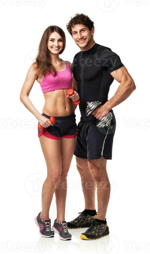 Athletic couple - man and woman with dumbbells on white photo