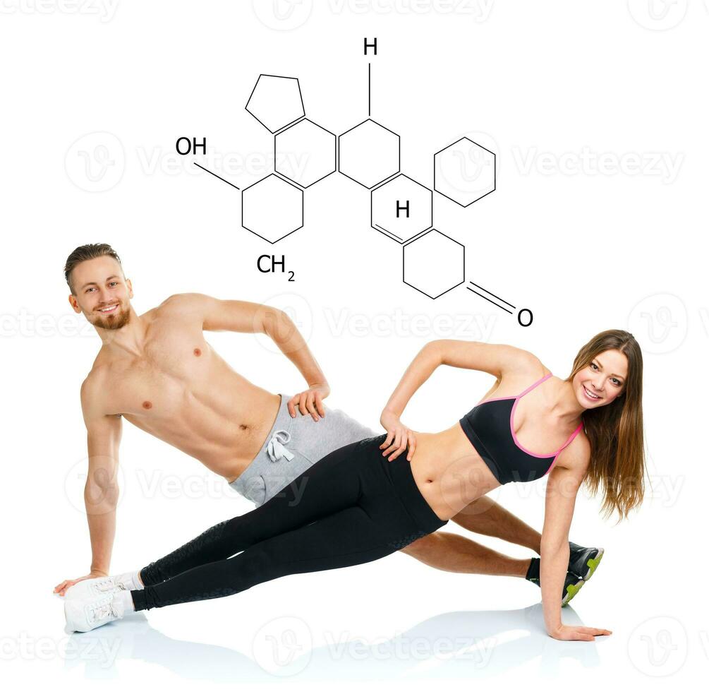 Athletic attractive couple - man and woman doing fitness exercises with the chemical formula on background - concept of healthy life photo