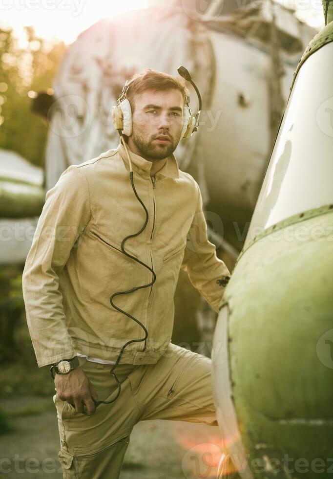 Young pilot posing near the helicopter photo