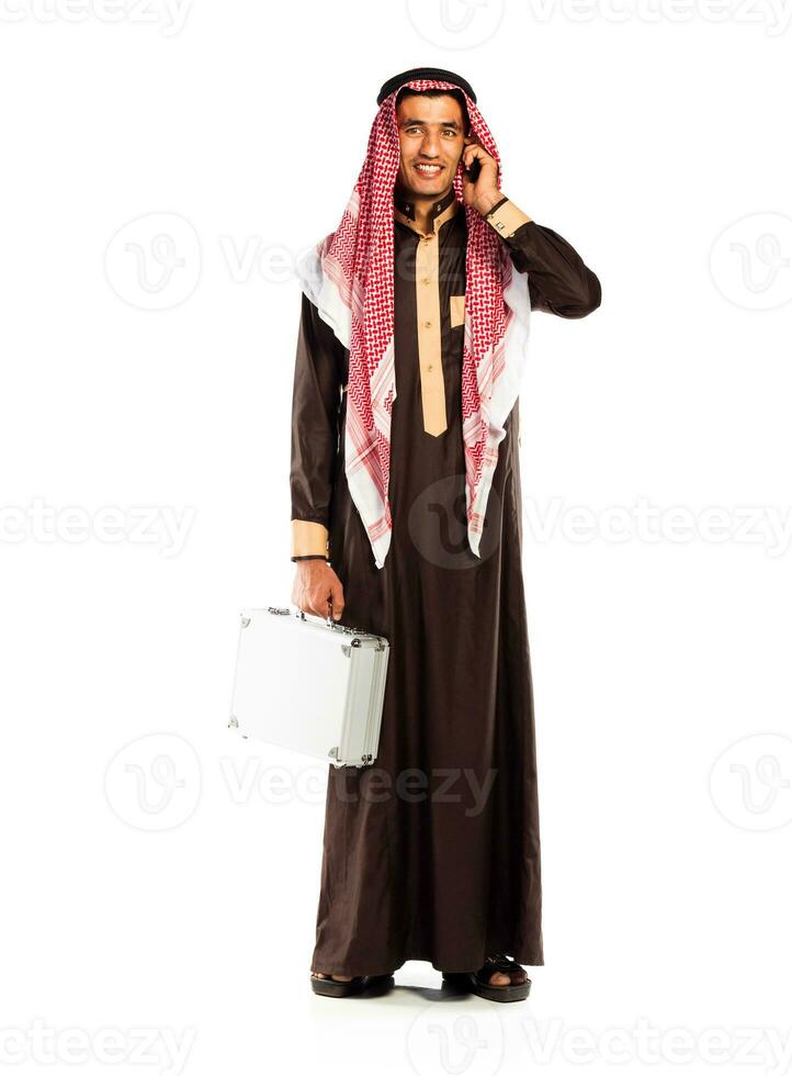 Young smiling arab with a aluminum case and cellphone isolated on white photo