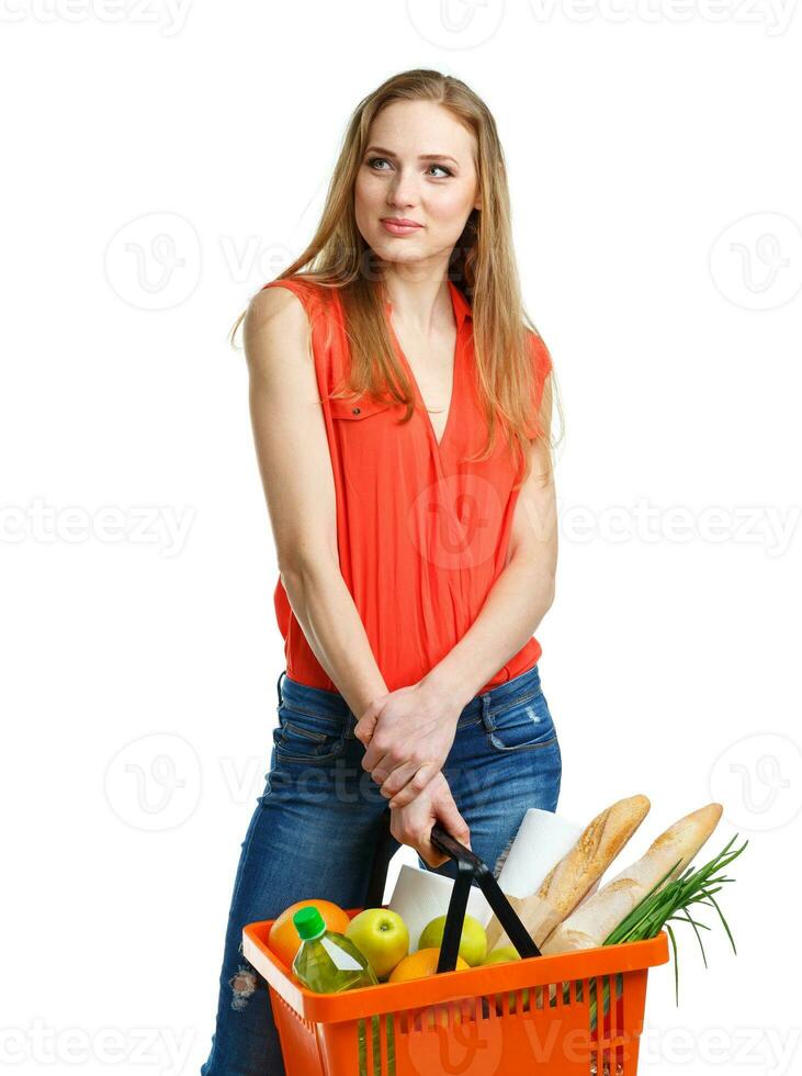 Young caucasian woman with assorted grocery products in shopping basket isolated on white photo