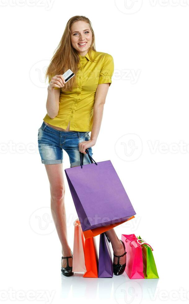 Happy caucasian woman with shopping bags and holding credit card on white background photo