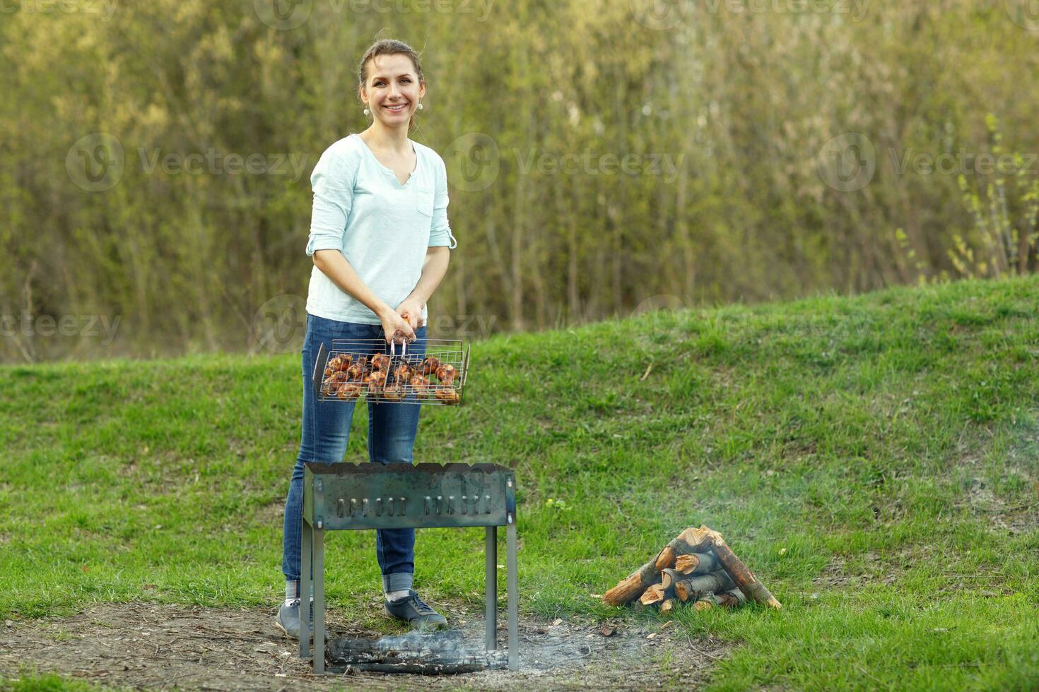 Young girl preparing food on grill photo