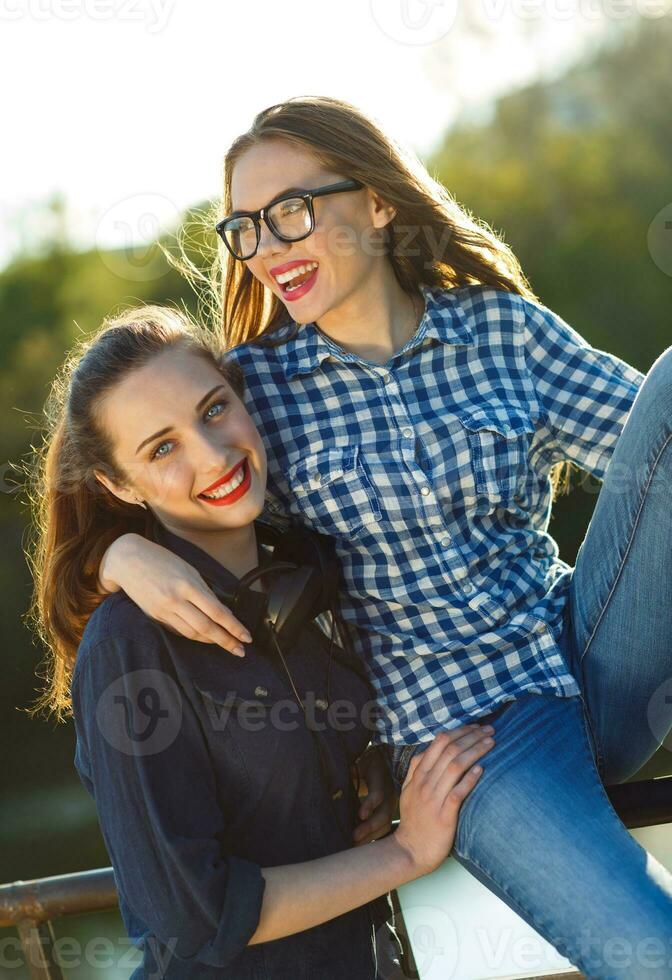 dos juguetón joven niña teniendo divertido al aire libre a puesta de sol ligero foto