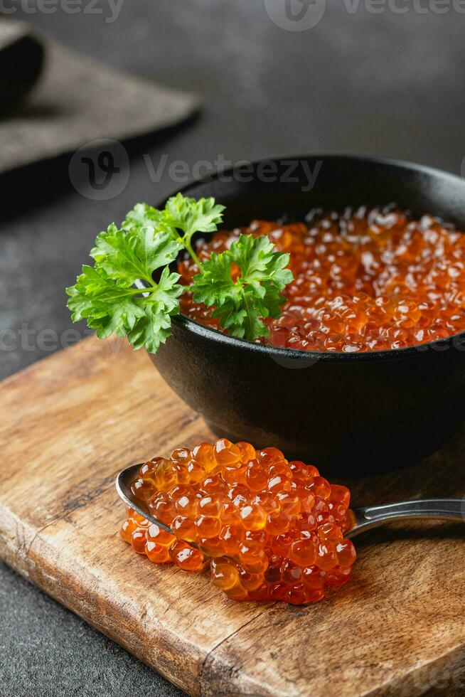 caviar de salmón rojo con perejil en un bol foto