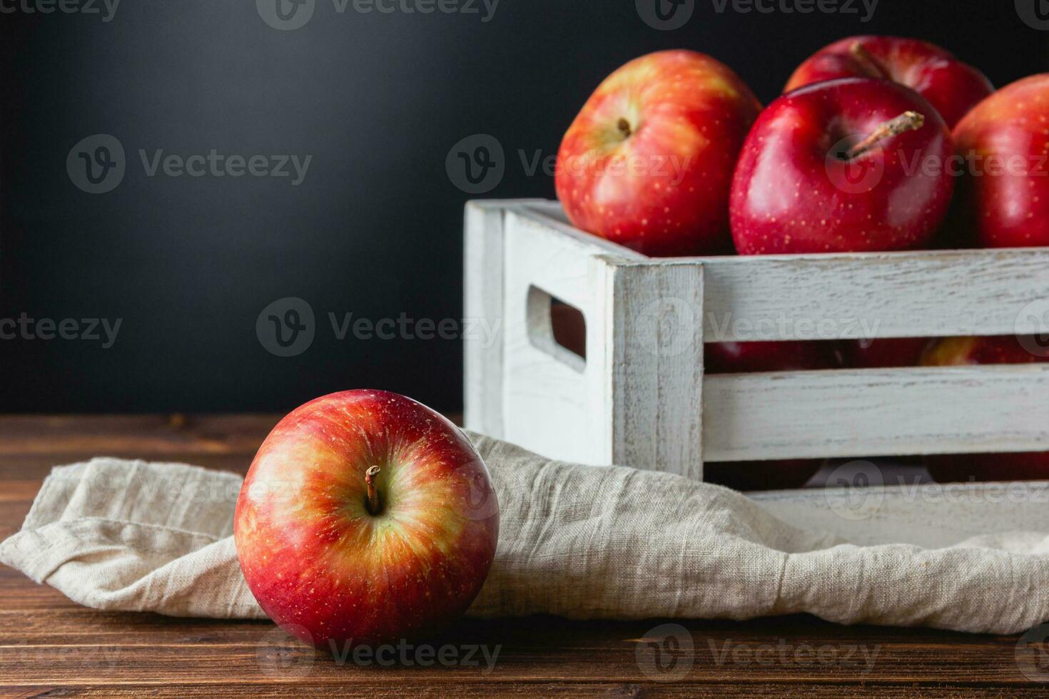 rojo manzanas en un caja en un de madera antecedentes foto