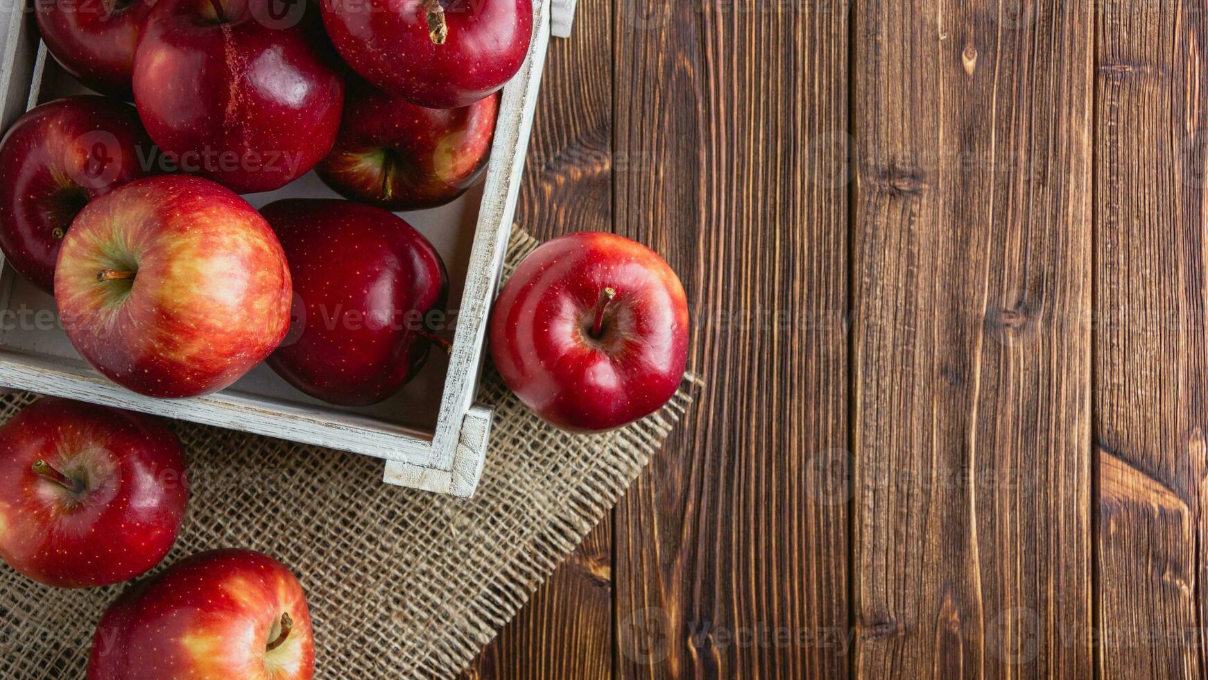 rojo manzanas en un caja en un de madera antecedentes foto