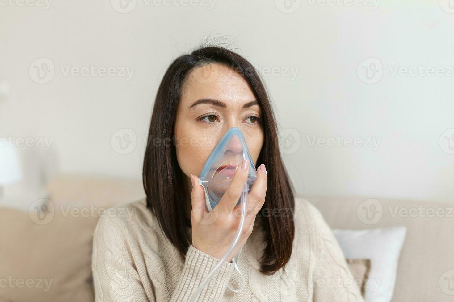 Sick Asian woman making inhalation, medicine is the best medicine. Ill woman wearing an oxygen mask and undergoing treatment for covid-19. woman with an inhaler photo