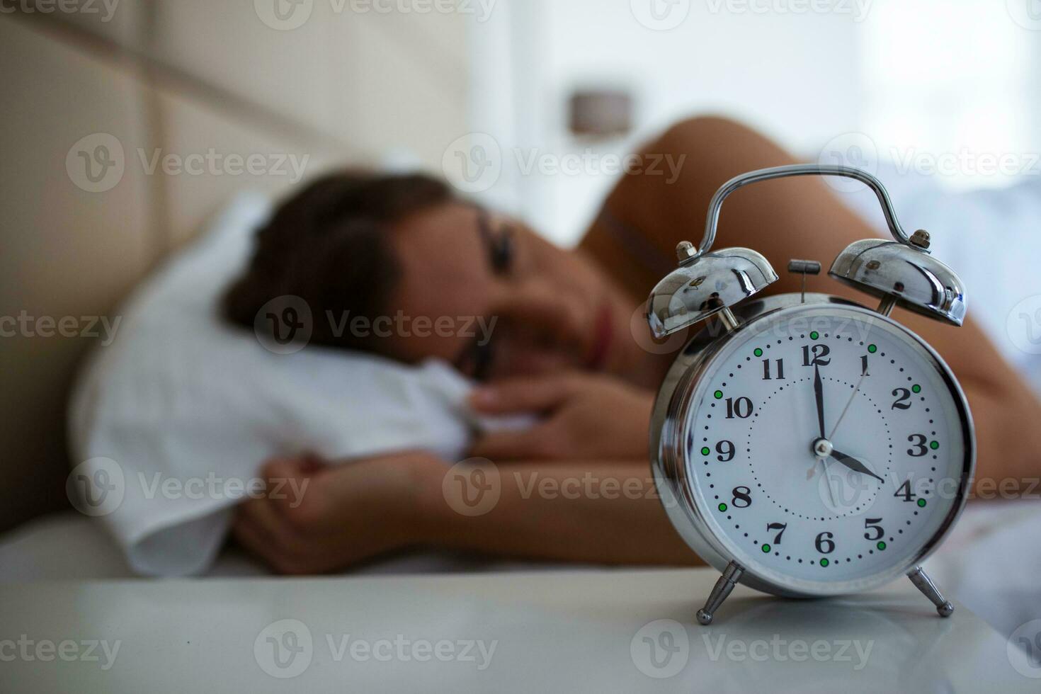 Woman with insomnia lying in bed with open eyes. Girl in bed suffering insomnia and sleep disorder thinking about his problem at night photo