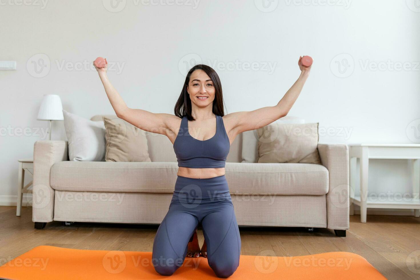 Asian woman exercise with dumbbells at home. Happy female doing arm workout using dumbbells photo