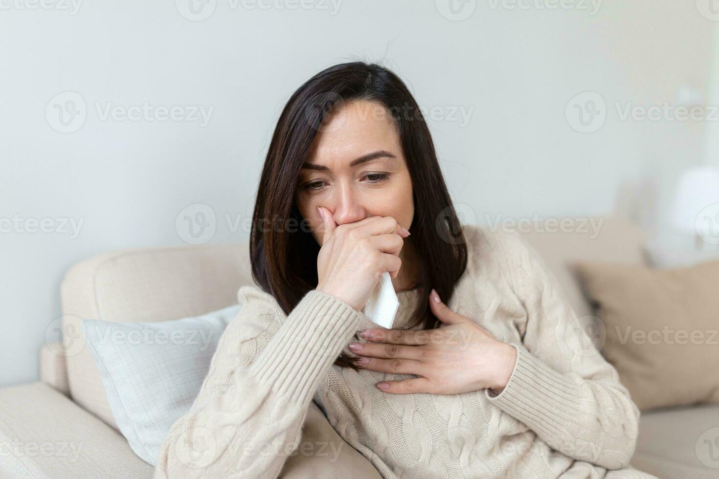 Unhappy young woman covering face with hands, crying alone close up, depressed girl sitting on couch at home, health problem or thinking about bad relationships, break up with boyfriend, divorce photo