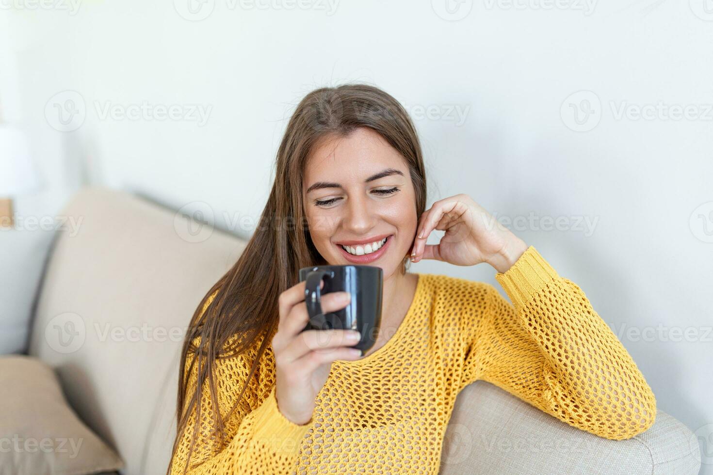 Closeup view of young woman with cup of hot drink at home, blank space. People, drinks and leisure concept - happy young woman with cup of tea or coffee at home photo