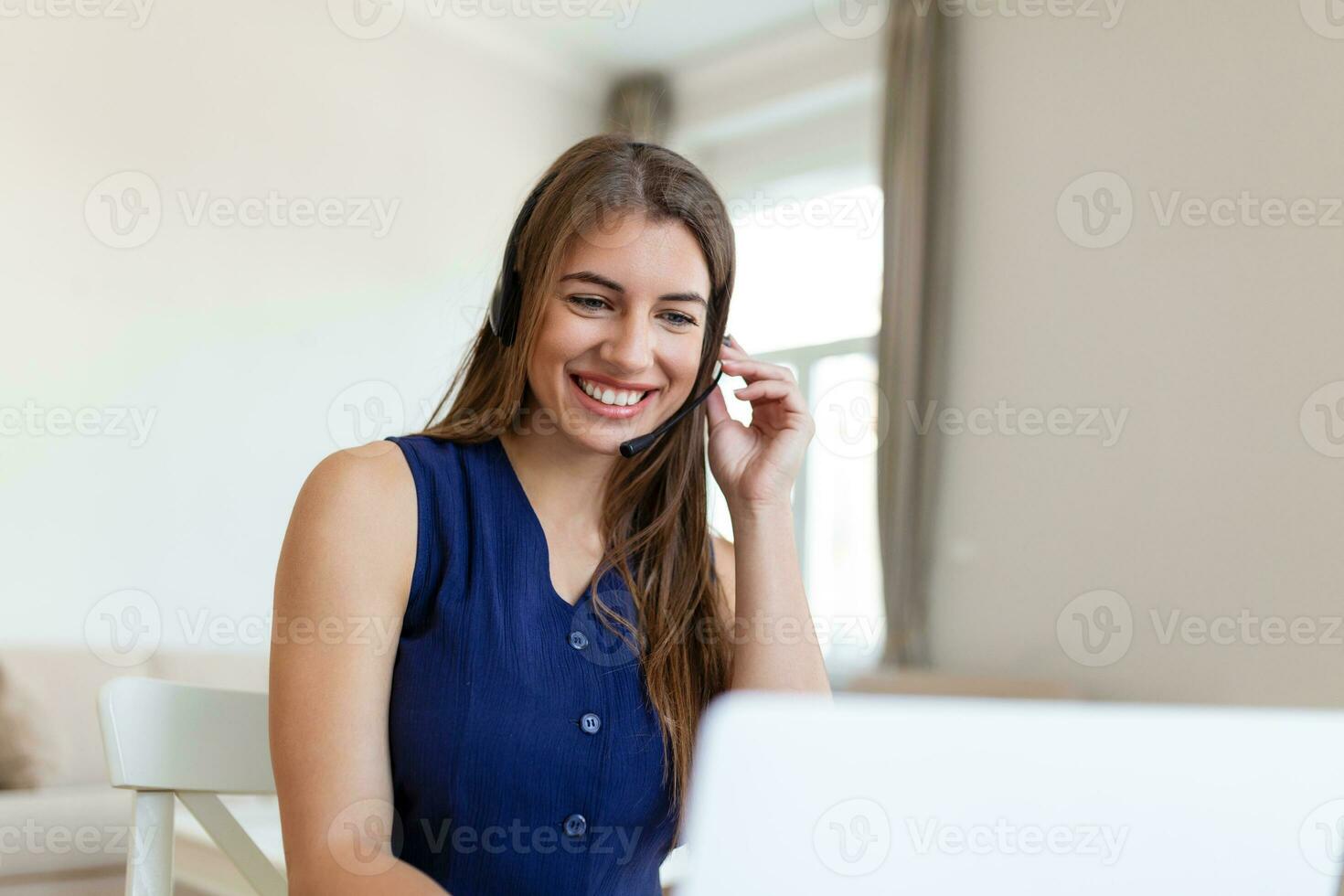 Happy young woman in headphones speaking looking at laptop making notes, business woman talking by video conference call, Conference by webcam, online training, e-coaching concept photo