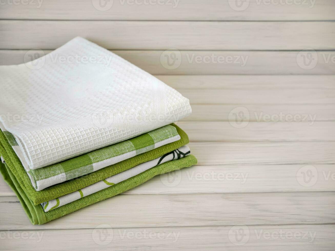 A pile of neatly folded towels on wooden background. Production of natural textile fibers.Organic product. Natural cloth photo
