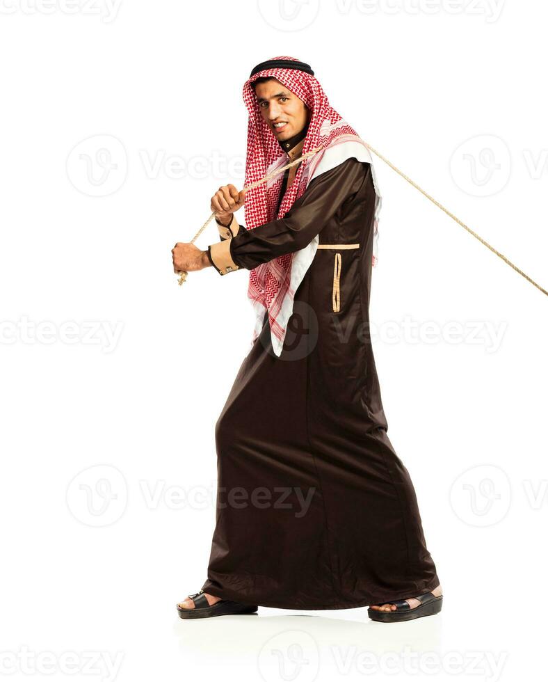 Young Arab pulling a rope isolated on white photo