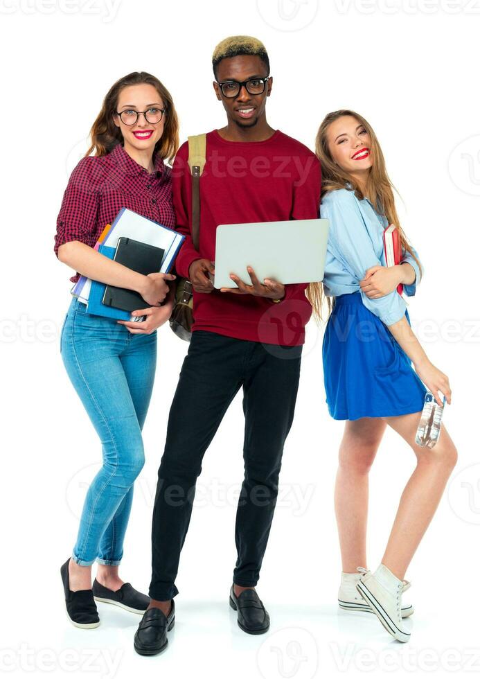 Happy students standing and smiling with books, laptop and bags isolated on white photo