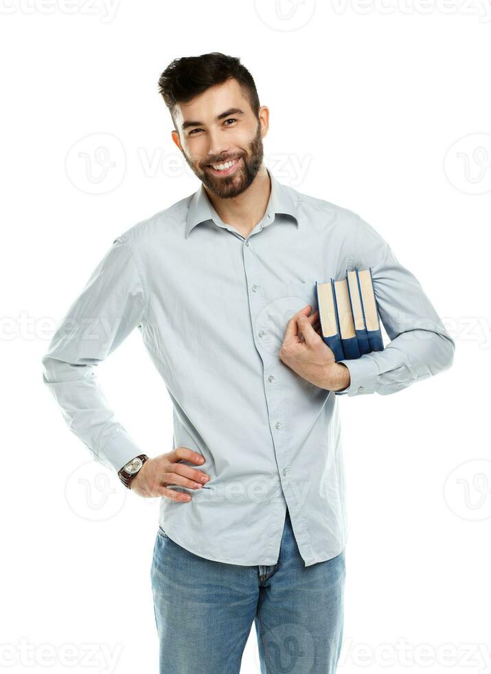 Young bearded smiling man with books in hand on white photo