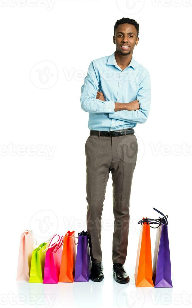 Happy african american man with shopping bags on white background photo
