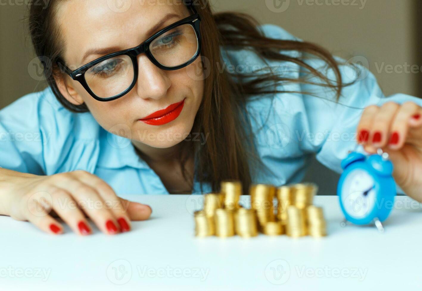 Woman stacking gold coins into columns photo