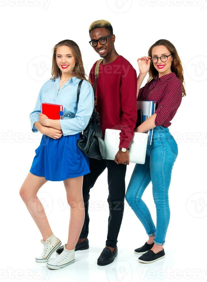 Happy students standing and smiling with books, laptop and bags isolated on white photo