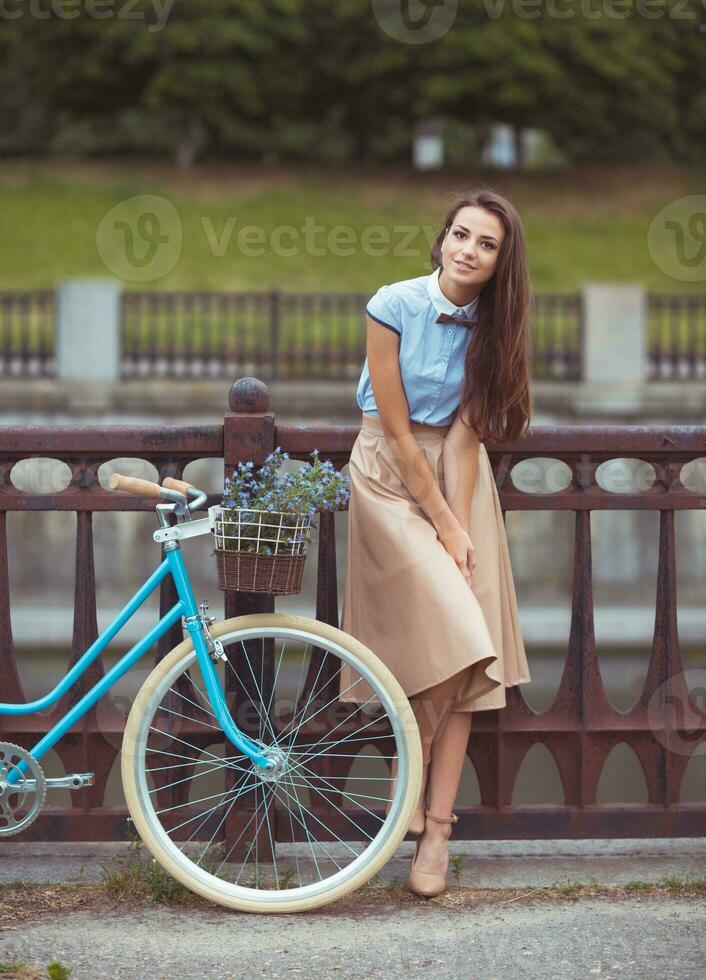 joven mujer hermosa, elegantemente vestida con bicicleta foto
