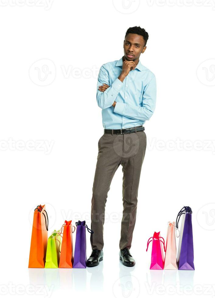 Happy african american man with shopping bags on white photo