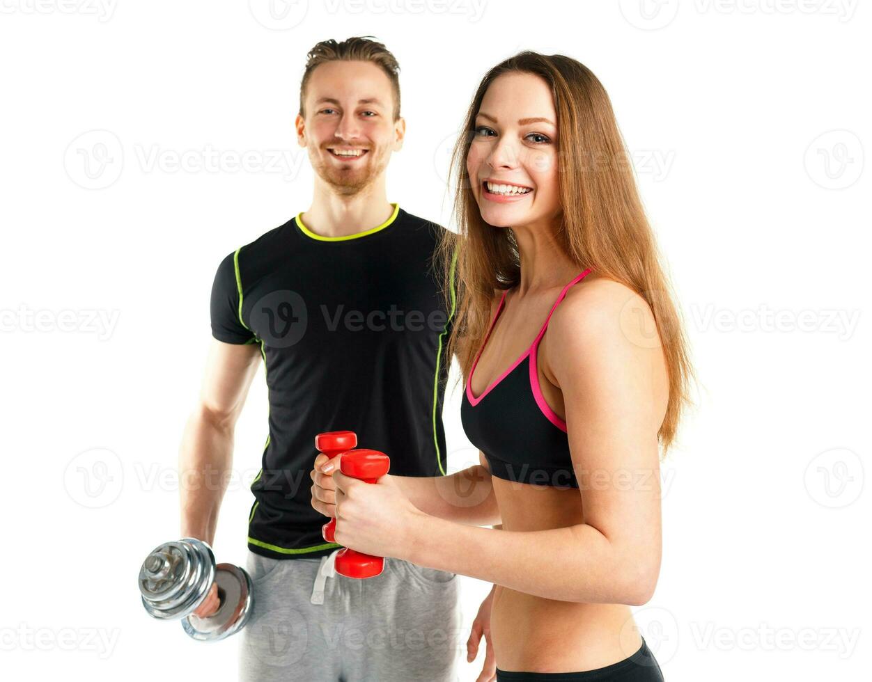 Athletic man and woman with dumbbells on the white photo